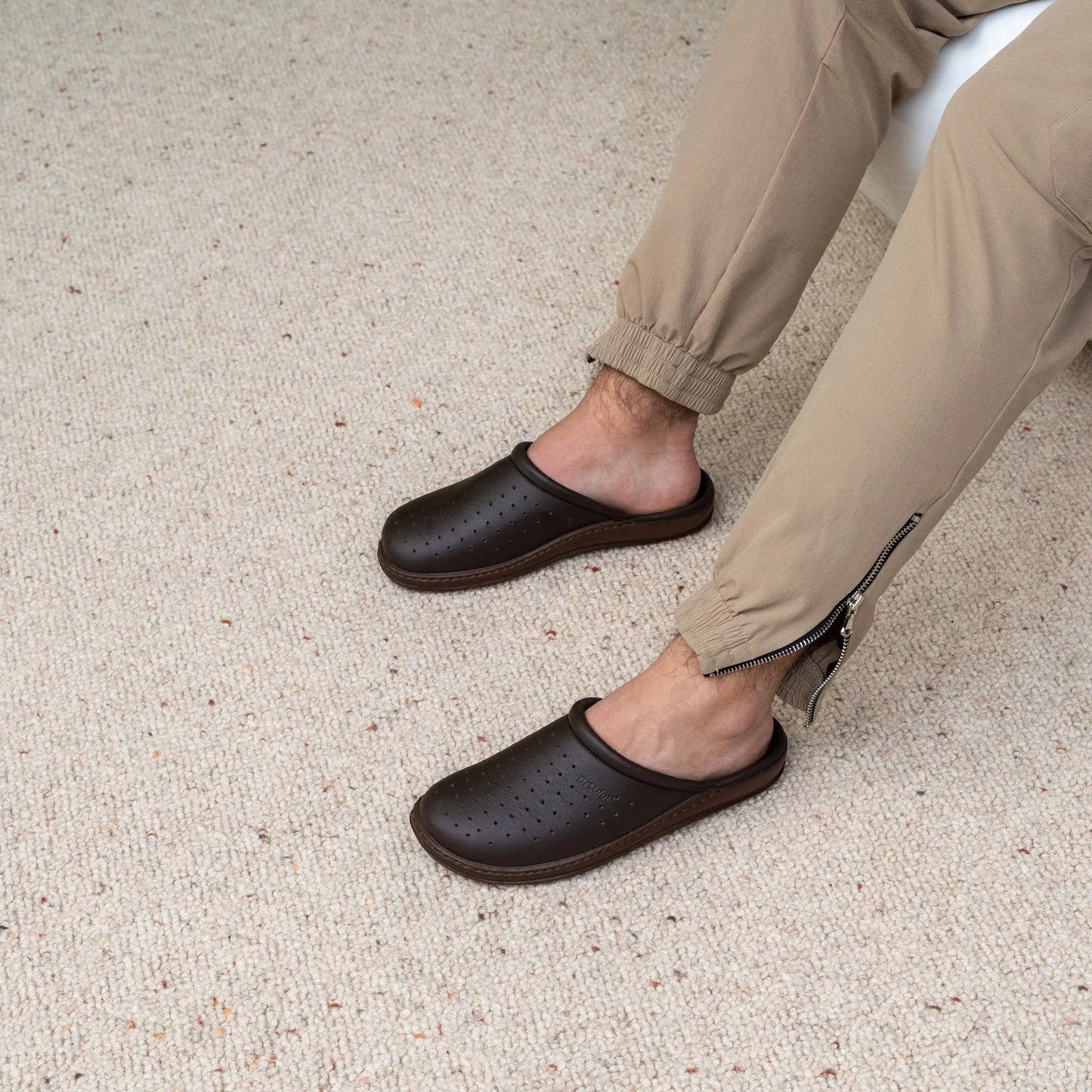 Man wearing DrLuigi® brown leather orthopedic clogs, seated pose