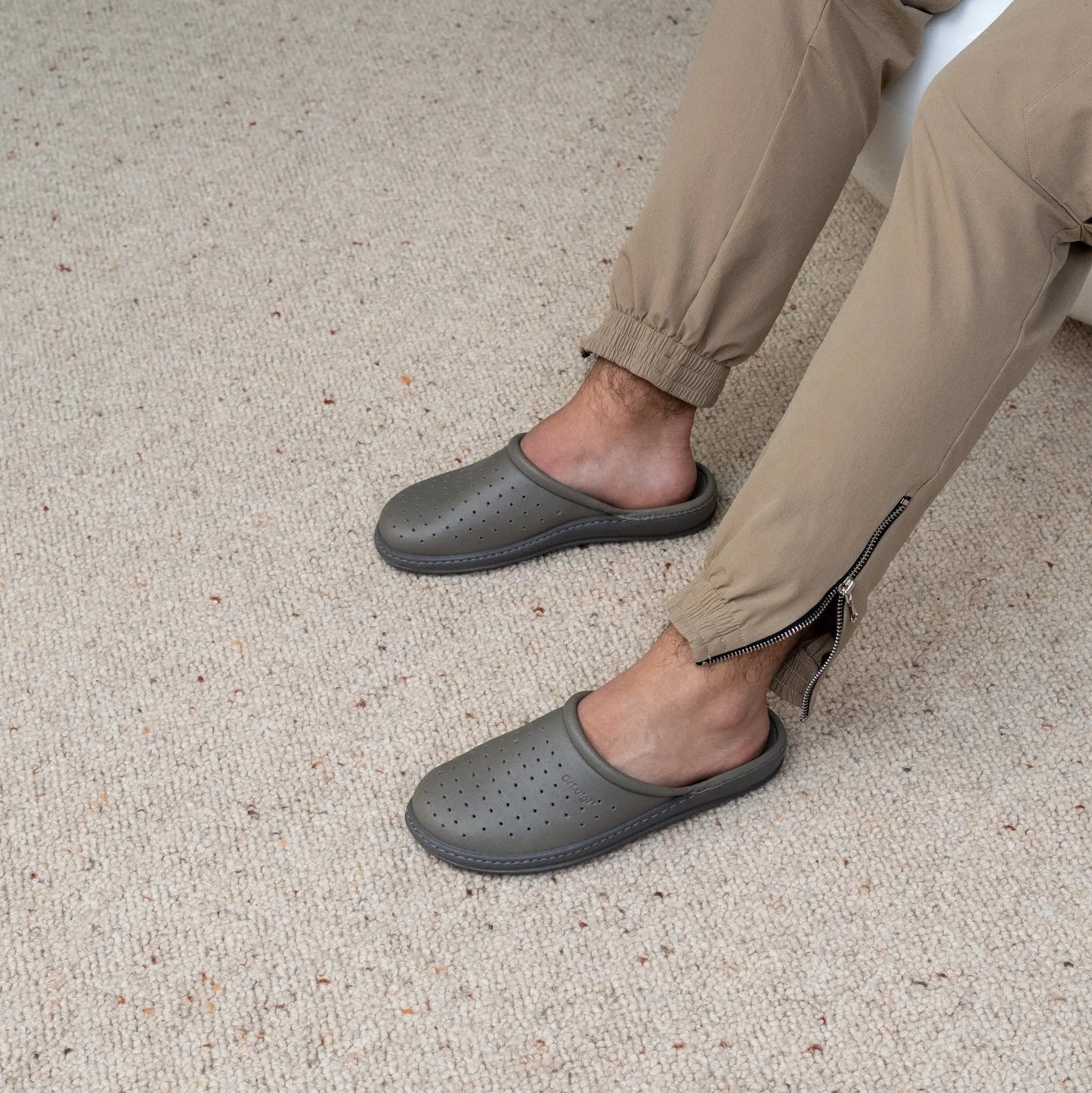 Man wearing DrLuigi® grey leather orthopedic clogs, seated pose