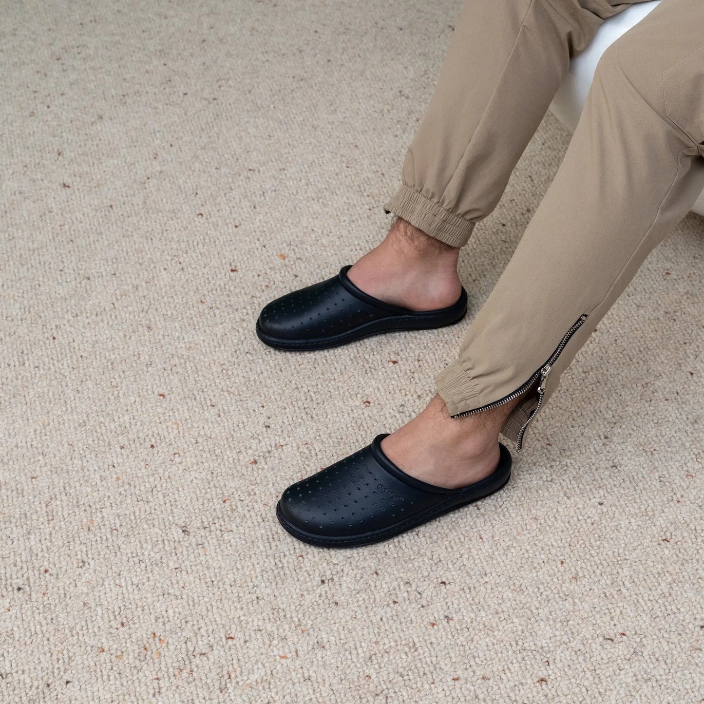 Man wearing DrLuigi® navy blue leather orthopedic clogs, seated pose