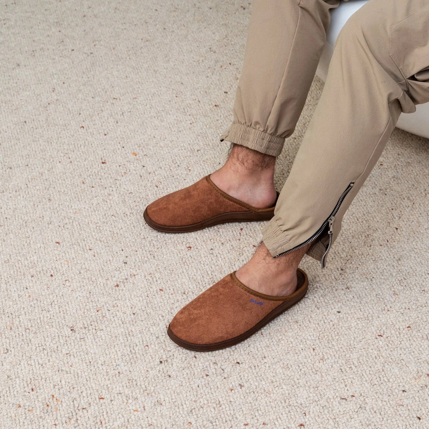 Man wearing DrLuigi® brown cotton medical slippers, seated pose