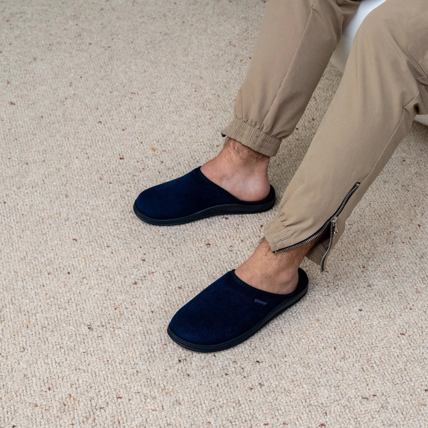 Man wearing DrLuigi® navy blue cotton medical slippers, seated pose