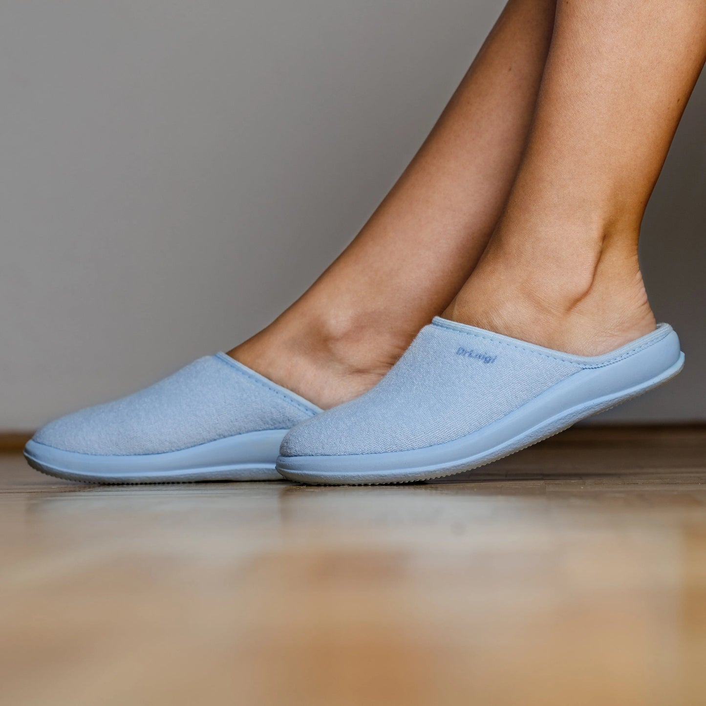 Woman wearing DrLuigi® baby blue cotton medical slippers, standing view