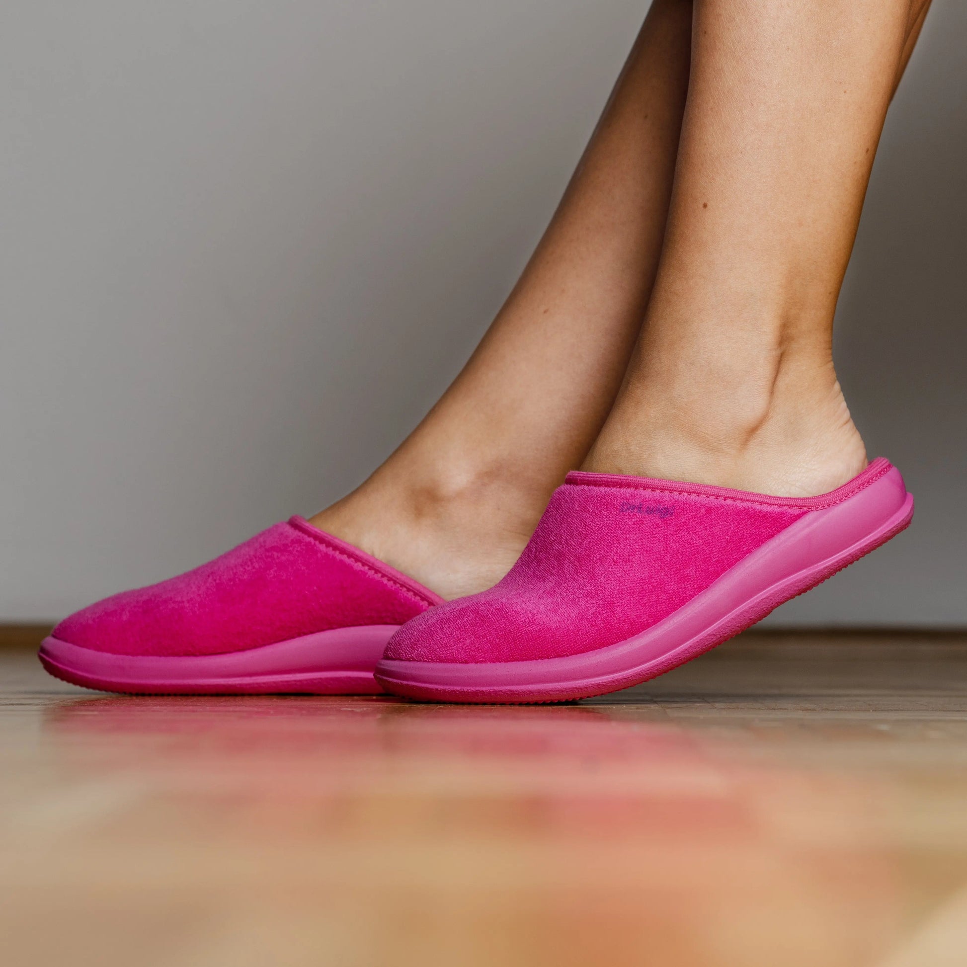 Woman wearing DrLuigi® fuchsia cotton medical slippers, standing view
