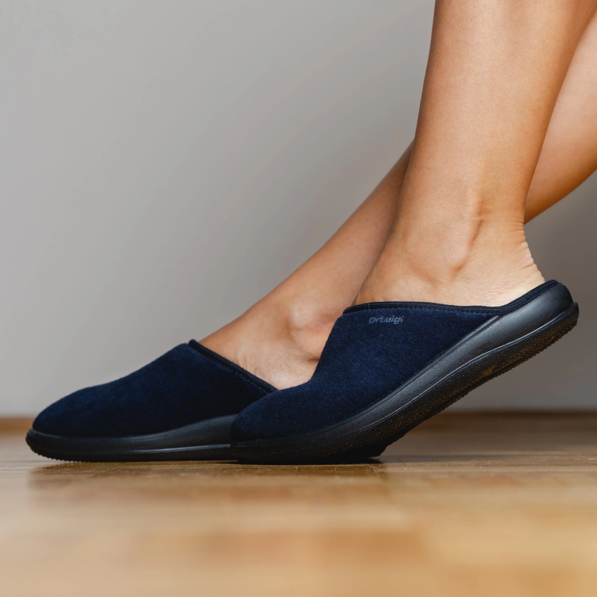 Woman wearing DrLuigi® navy blue cotton medical slippers, standing view
