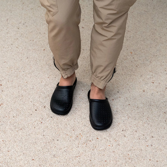 Man wearing DrLuigi® black leather orthopedic clogs, standing view