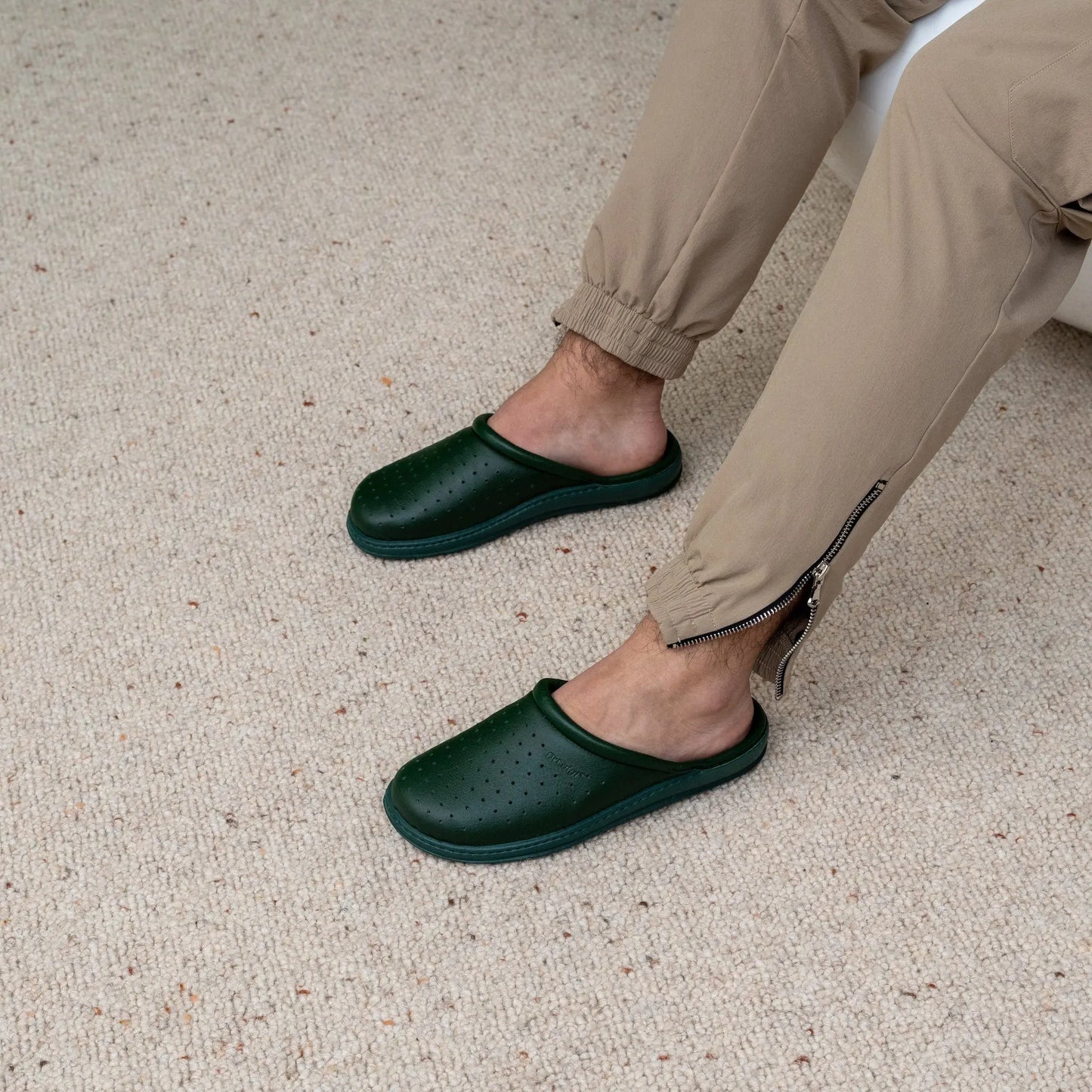 Man wearing DrLuigi® green leather orthopedic clogs, seated pose